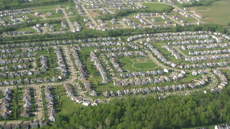 Aerial view of a suburban neighborhood surrounded by trees