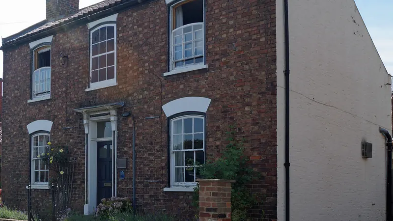 Brick house with dark gutters and downspouts