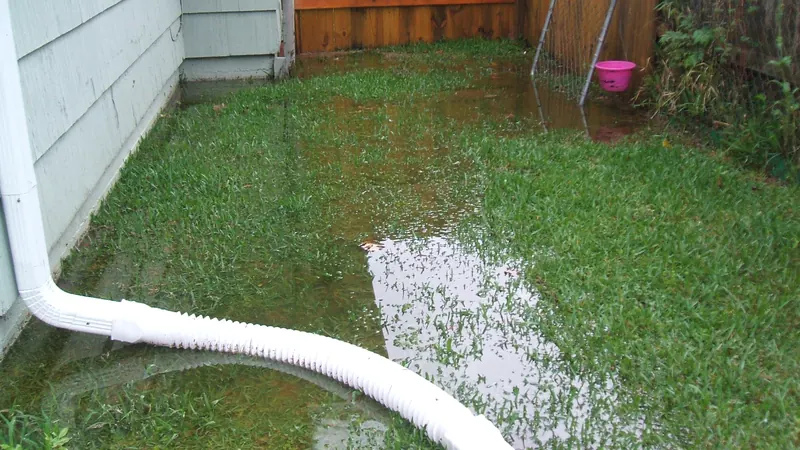 Flexible downspout extension carrying water across a lawn