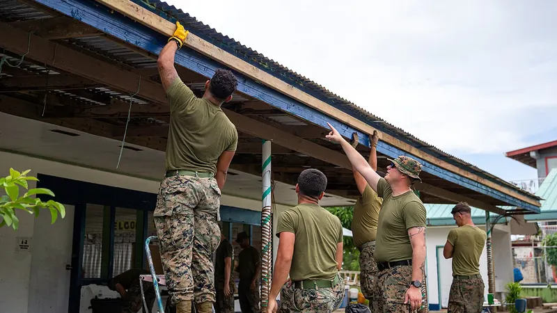 Crew fastening a new gutter along the roof edge of a one-story building