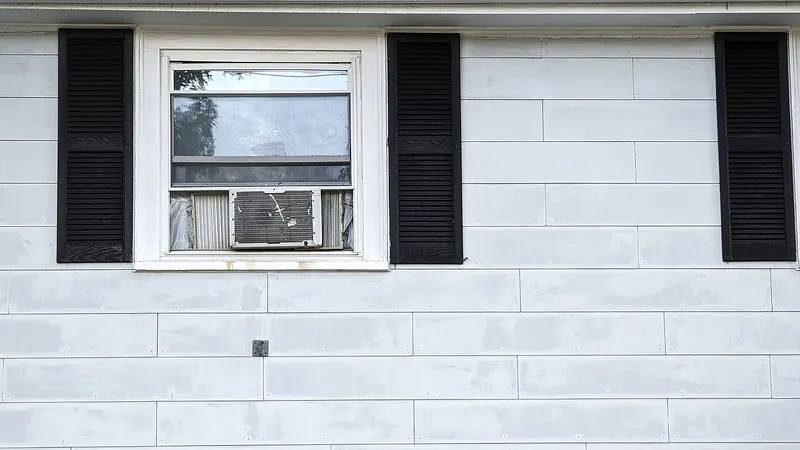 Window in a white-painted siding wall